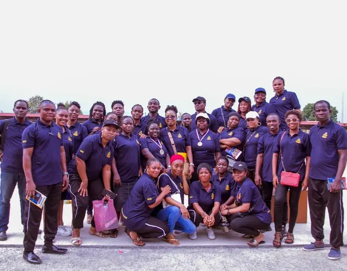 BlossomHill teachers and staff in matching navy school shirts posing as a group outdoors